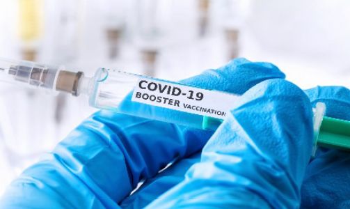 A syringe labeled COVID-19 booster.