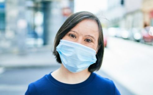 Middle aged woman smiling behind a mask.